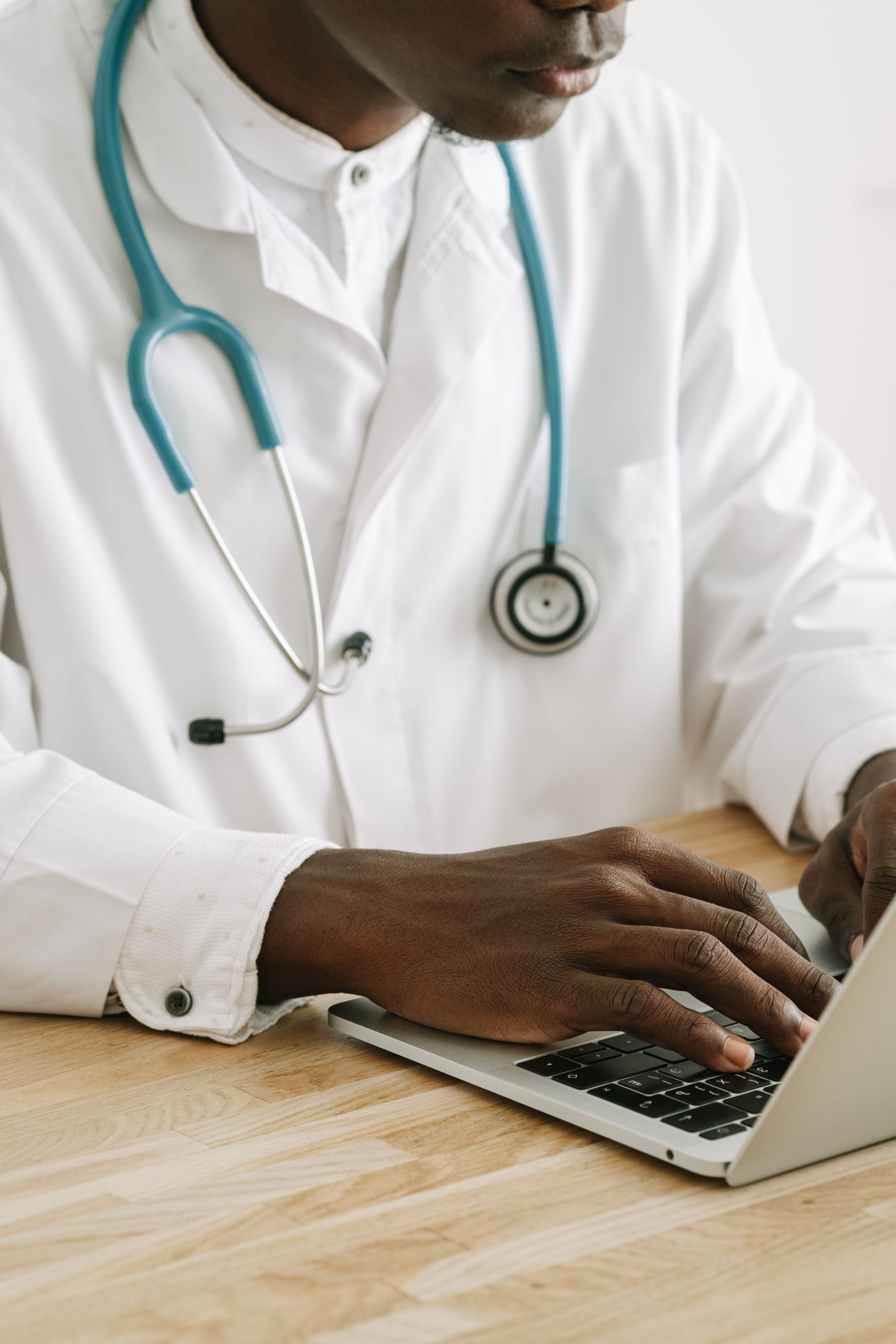 Médico trabajando con una computadora portátil en su consultorio